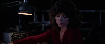 Movie still from “The Fog” (1980), directed by John Carpenter – A woman in a red shirt is sitting in front of a microphone; Close Up shot, Low angle