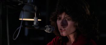 Movie still from “The Fog” (1980), directed by John Carpenter – A person with a microphone in front of a microphone stand; Close Up shot, Low angle