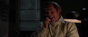 Movie still from “The Fog” (1980), directed by John Carpenter – A man talking on a phone while wearing a sweater; Close Up shot, Over the shoulder angle