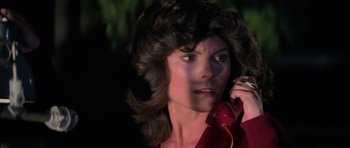 Movie still from “The Fog” (1980), directed by John Carpenter – A woman in a red shirt talking on a red phone; Close Up shot, Low angle