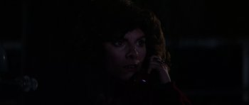 Movie still from “The Fog” (1980), directed by John Carpenter – A woman is talking on a cell phone in the dark; Close Up shot, High angle