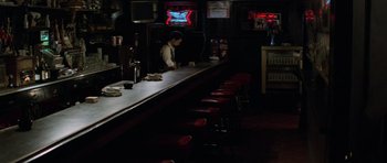 Movie still from “The Fog” (1980), directed by John Carpenter – A man sitting at a bar in front of a television; Wide shot, High angle