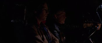 Movie still from “The Fog” (1980), directed by John Carpenter – A man and a woman sitting next to each other in the dark; Close Up shot, Over the shoulder angle