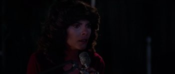 Movie still from “The Fog” (1980), directed by John Carpenter – A woman is holding a microphone in a dark room; Close Up shot, Low angle