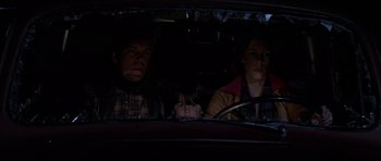 Movie still from “The Fog” (1980), directed by John Carpenter – Three people sitting in the back of a car at night; Medium shot, High angle
