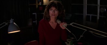 Movie still from “The Fog” (1980), directed by John Carpenter – A woman in a red shirt is holding a microphone; Close Up shot, Low angle