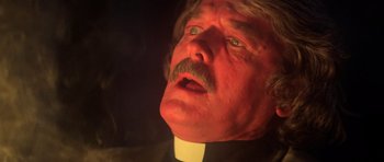 Movie still from “The Fog” (1980), directed by John Carpenter – A person wearing a clerical collar; Close Up shot, Low angle