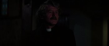 Movie still from “The Fog” (1980), directed by John Carpenter – A man in a priest's outfit looking into the dark; Close Up shot, Low angle