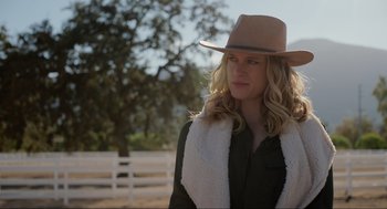 Movie still from “The Forever Purge” (2021), directed by Everardo Gout – A woman wearing a cowboy hat standing next to a white fence; Close Up shot, Low angle