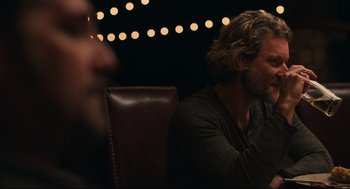 Movie still from “The Forever Purge” (2021), directed by Everardo Gout – A man sitting in a chair with a beard; Close Up shot, Over the shoulder angle