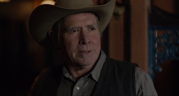 Movie still from “The Forever Purge” (2021), directed by Everardo Gout – An older man wearing a cowboy hat in a dark room; Close Up shot, Over the shoulder angle