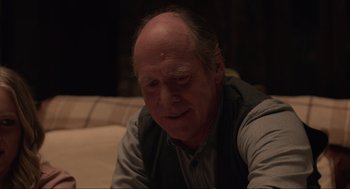 Movie still from “The Forever Purge” (2021), directed by Everardo Gout – An older man sitting on a couch looking at the camera; Close Up shot, Over the shoulder angle