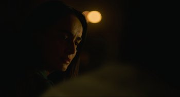 Movie still from “The Forever Purge” (2021), directed by Everardo Gout – A woman is looking at the camera with a blurry background; Close Up shot, Over the shoulder angle