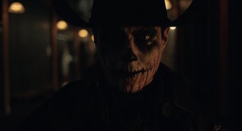 Movie still from “The Forever Purge” (2021), directed by Everardo Gout – A man with a face paint and a hat; Close Up shot, Low angle