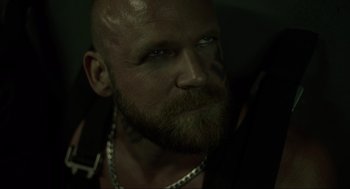 Movie still from “The Forever Purge” (2021), directed by Everardo Gout – A man with a beard is looking at the camera; Close Up shot, Over the shoulder angle