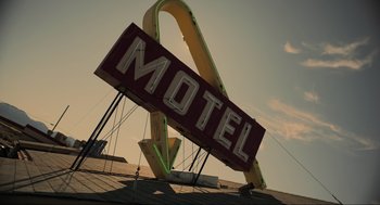 Movie still from “The Forever Purge” (2021), directed by Everardo Gout – An old motel sign on top of the roof of a building; Extreme Wide shot, Low angle