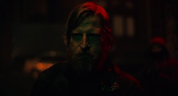 Movie still from “The Forever Purge” (2021), directed by Everardo Gout – A man with long hair and a goatee is looking at the camera; Close Up shot, Over the shoulder angle