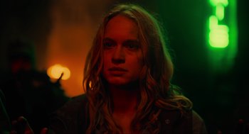 Movie still from “The Forever Purge” (2021), directed by Everardo Gout – A woman with long blonde wavy hair wearing a black jacket; Close Up shot, Over the shoulder angle