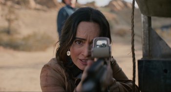 Movie still from “The Forever Purge” (2021), directed by Everardo Gout – A woman is holding a gun and looking at the camera; Close Up shot, Over the shoulder angle
