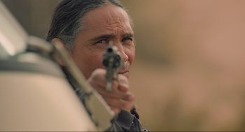 Movie still from “The Forever Purge” (2021), directed by Everardo Gout – A man holding a gun up to his face; Close Up shot, Over the shoulder angle