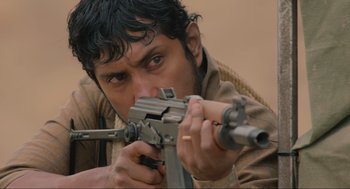 Movie still from “The Forever Purge” (2021), directed by Everardo Gout – A man is holding a rifle and aiming it; Close Up shot, Low angle
