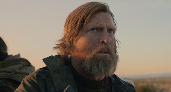 Movie still from “The Forever Purge” (2021), directed by Everardo Gout – A person with long hair and a beard; Close Up shot, Low angle