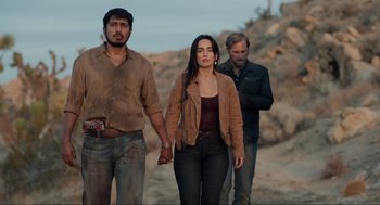 Movie still from “The Forever Purge” (2021), directed by Everardo Gout – A man and a woman holding hands while walking with another man; Medium shot, Low angle