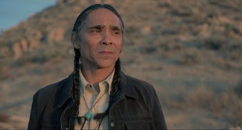 Movie still from “The Forever Purge” (2021), directed by Everardo Gout – A man with long black hair wearing a black jacket; Close Up shot, Over the shoulder angle