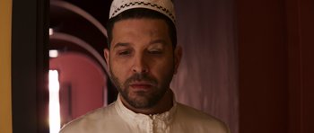 Movie still from “The Forgiven” (2021), directed by John Michael McDonagh – A person wearing a hat; Close Up shot, Low angle