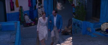 Movie still from “The Forgiven” (2021), directed by John Michael McDonagh – A man and a woman walking down a street; Wide shot, High angle