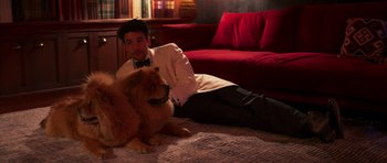 Movie still from “The Forgiven” (2021), directed by John Michael McDonagh – A man sitting on the ground with a dog; Medium shot, High angle