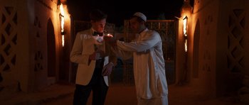 Movie still from “The Forgiven” (2021), directed by John Michael McDonagh – Two men standing next to each other holding a lit candle; Medium shot, Over the shoulder angle