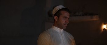 Movie still from “The Forgiven” (2021), directed by John Michael McDonagh – A man wearing a white hat is looking at the camera; Close Up shot, Low angle