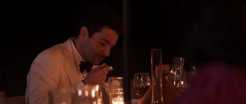 Movie still from “The Forgiven” (2021), directed by John Michael McDonagh – A man sitting at a dinner table eating a piece of cake; Medium shot, High angle