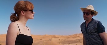 Movie still from “The Forgiven” (2021), directed by John Michael McDonagh – A woman in sunglasses standing in the middle of a desert; Medium shot, Low angle