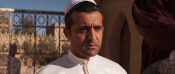 Movie still from “The Forgiven” (2021), directed by John Michael McDonagh – A person wearing a hat; Close Up shot, Over the shoulder angle