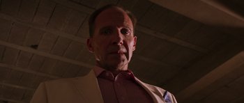 Movie still from “The Forgiven” (2021), directed by John Michael McDonagh – A person wearing a suit and tie; Close Up shot, Low angle