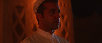 Movie still from “The Forgiven” (2021), directed by John Michael McDonagh – A person wearing a hat; Close Up shot, Low angle