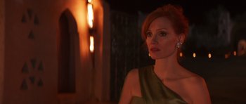 Movie still from “The Forgiven” (2021), directed by John Michael McDonagh – A woman in a green dress is looking at the camera; Close Up shot, Over the shoulder angle