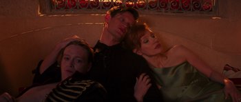 Movie still from “The Forgiven” (2021), directed by John Michael McDonagh – A man and two women laying on the ground; Medium shot, High angle