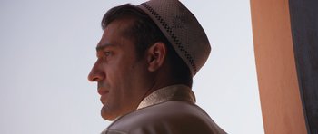 Movie still from “The Forgiven” (2021), directed by John Michael McDonagh – A person wearing a hat; Close Up shot, Low angle