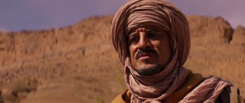 Movie still from “The Forgiven” (2021), directed by John Michael McDonagh – A person wearing a turban; Close Up shot, Over the shoulder angle