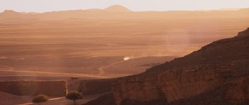 Movie still from “The Forgiven” (2021), directed by John Michael McDonagh – A view of a desert from a hill; Extreme Wide shot, High angle