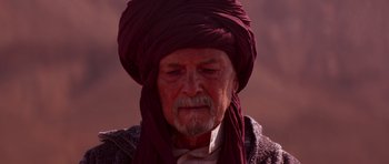 Movie still from “The Forgiven” (2021), directed by John Michael McDonagh – An old man wearing a turban in the desert; Close Up shot, Over the shoulder angle