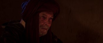 Movie still from “The Forgiven” (2021), directed by John Michael McDonagh – A person with a beard wearing a turban; Close Up shot, Over the shoulder angle