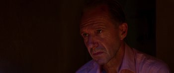 Movie still from “The Forgiven” (2021), directed by John Michael McDonagh – A person wearing a pink shirt; Close Up shot, High angle