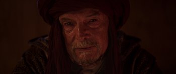 Movie still from “The Forgiven” (2021), directed by John Michael McDonagh – An old man with a beard and a hat on; Close Up shot, Over the shoulder angle