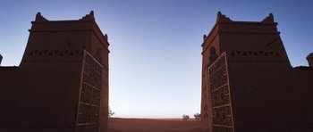 Movie still from “The Forgiven” (2021), directed by John Michael McDonagh – An open gate in the middle of an empty field; Extreme Wide shot, Low angle