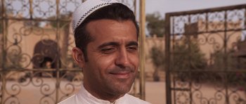 Movie still from “The Forgiven” (2021), directed by John Michael McDonagh – A person wearing a hat; Close Up shot, Over the shoulder angle