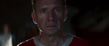 Movie still from “The Forgiven” (2021), directed by John Michael McDonagh – A person wearing a red and white shirt; Close Up shot, Low angle